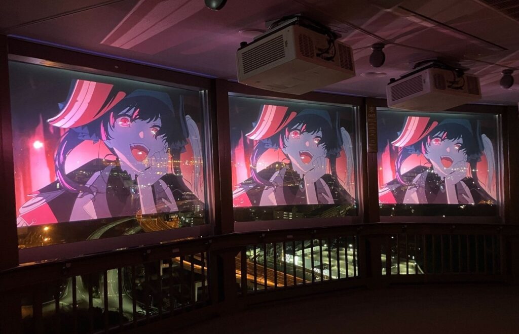 The inside of the observation deck of the Yokohama Marine Tower, with Houshou Marine's music video "Ghost Ship" projected onto the windows.