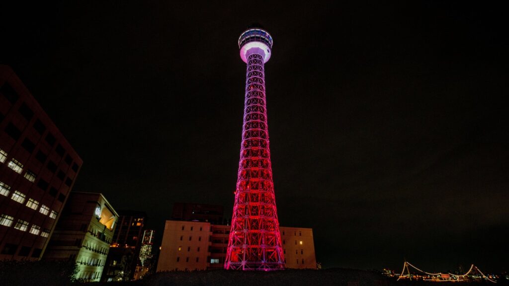 The outside of Yokohama Marine Tower lit up in red.