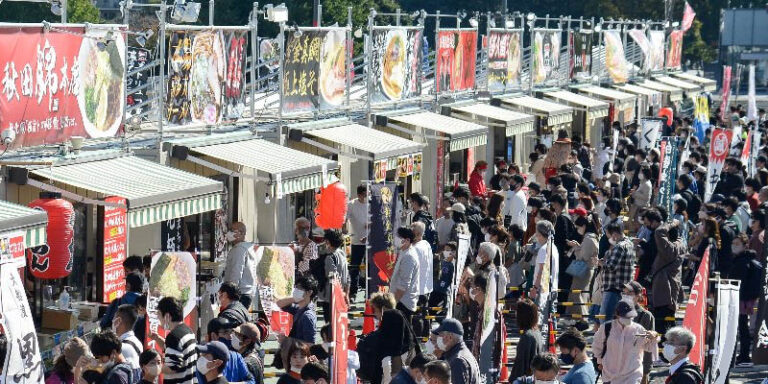 Ramen stalls with people waiting in line at Tokyo Ramen Festa