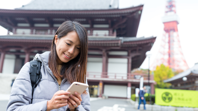 Tourist using phone near Tokyo Tower