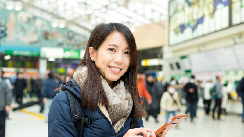 Tourist using phone in Ueno Station, Tokyo