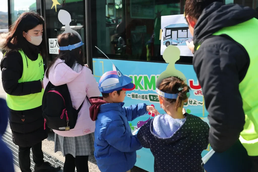 Children decorating a bus with Pikmin decals