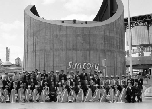 Suntory employees photographed in front of the Suntory Pavilion at Osaka Expo '70