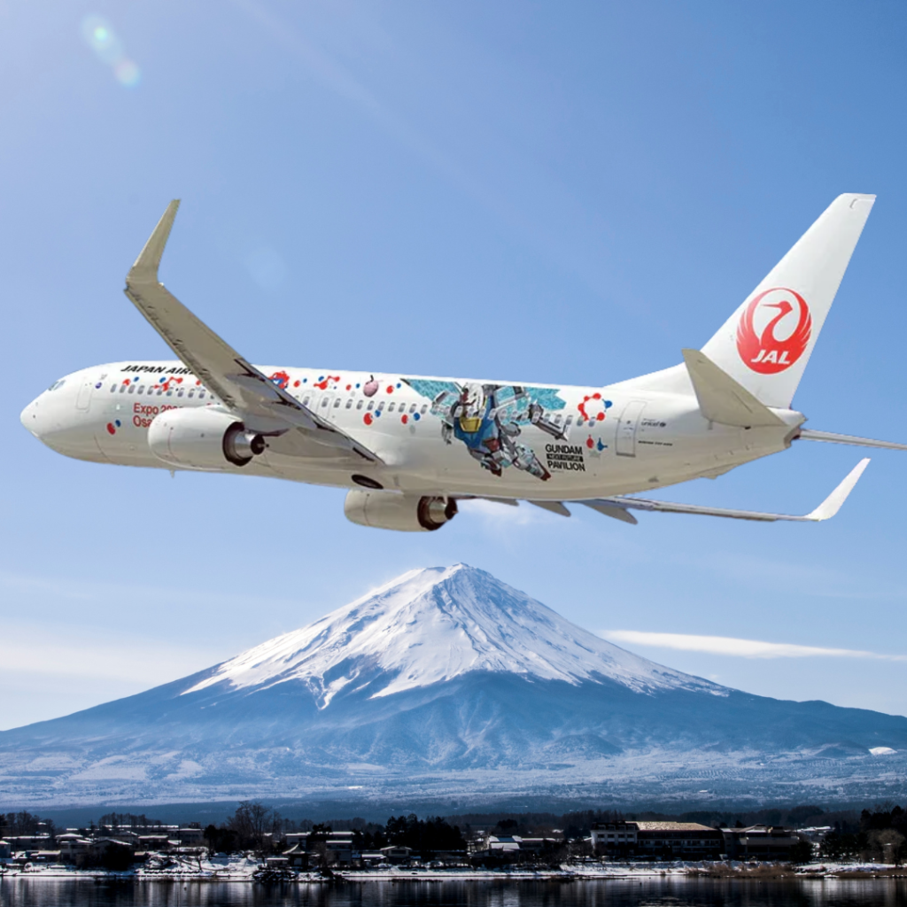 A Gundam themed plane flying in front of Mount Fuji