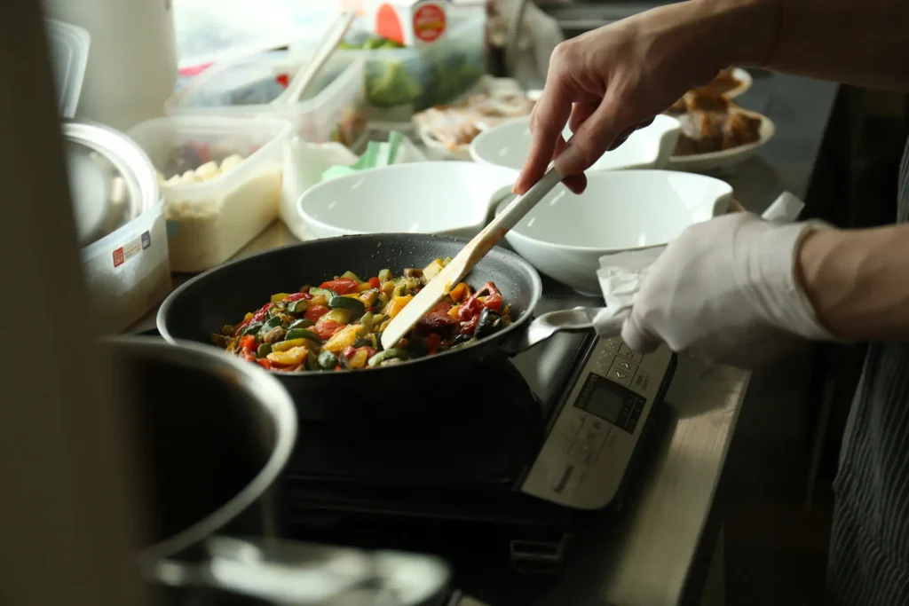 A person cooking on a portable hotplate