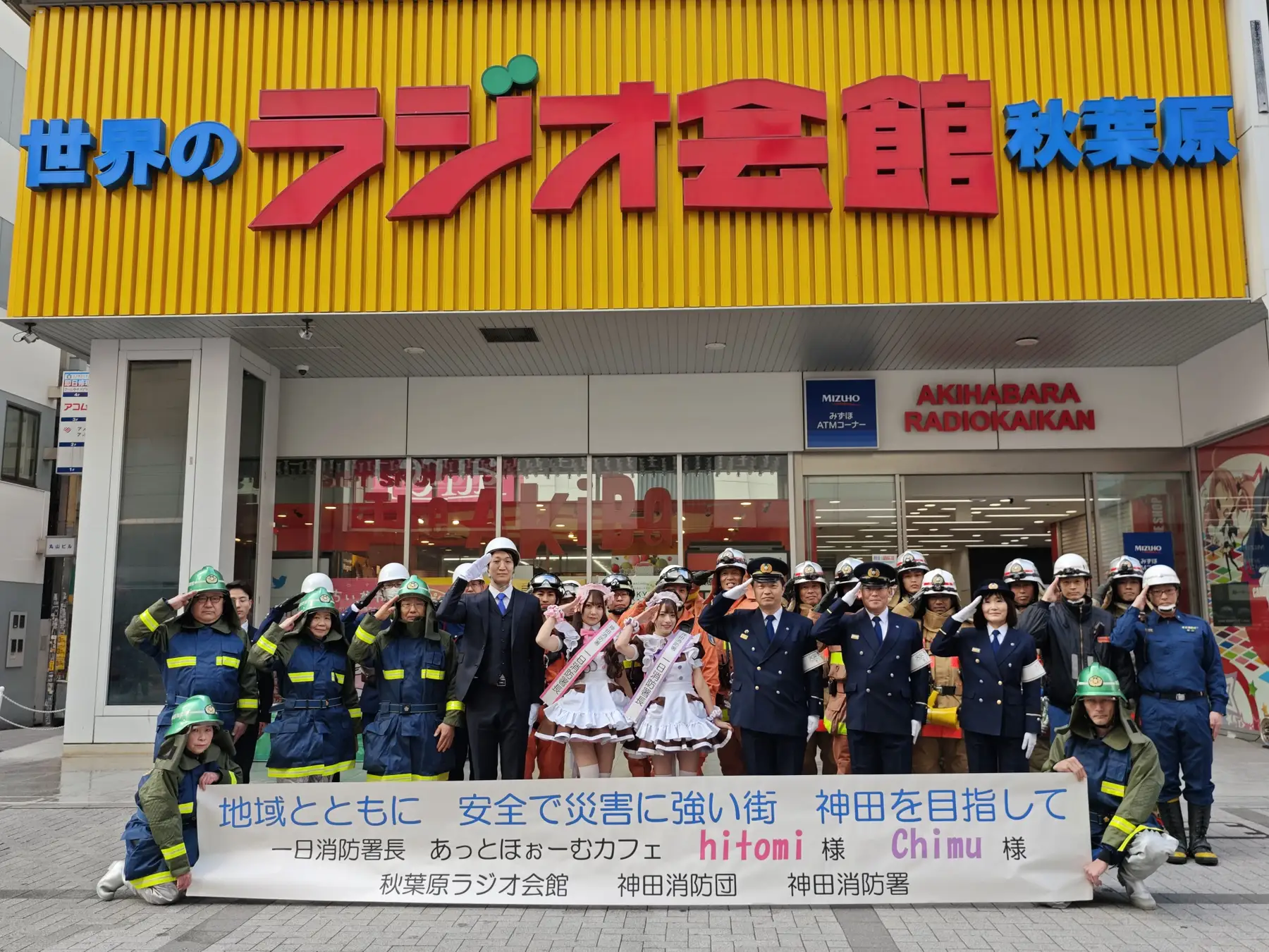 A group of fire fighters and maids standing outside the Radio Kaikan building A group of fire fighters and maids standing outside the Radio Kaikan building