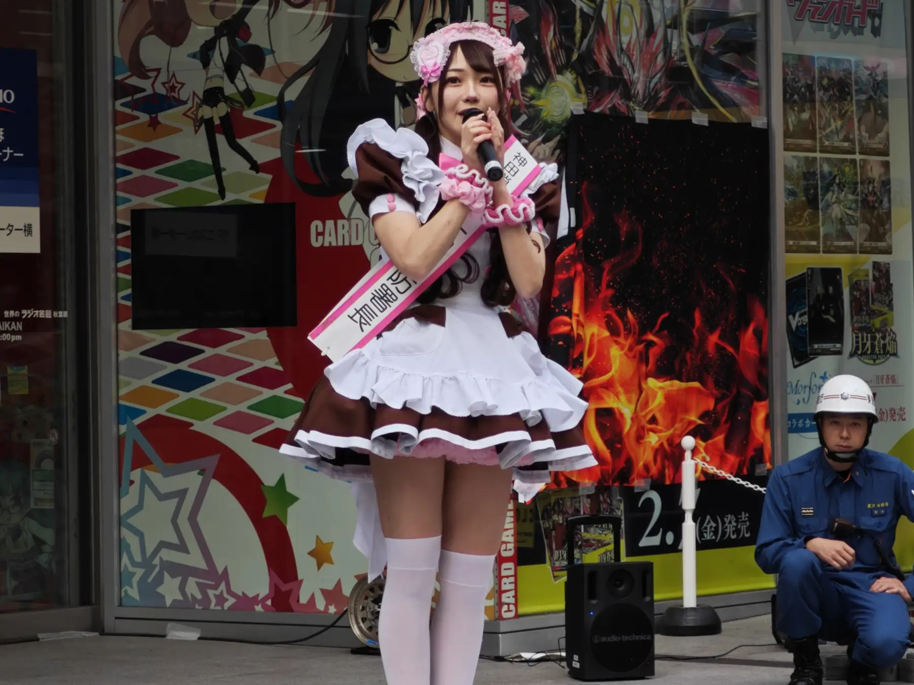 A maid talking into a microphone in Akihabara A maid talking into a microphone in Akihabara