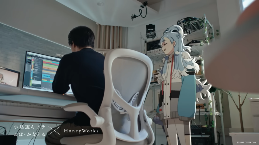 A man working at a desk while a virtual character stands beside him